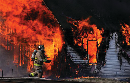 A Maysville firefighter prepares to battle a house fire on Feb. 23 that killed two small children.