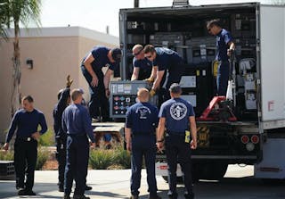 Los Angeles County firefighters move heavy equipment on to pallets as members of the L.A. County USAR team prepare to deploy to Japan.