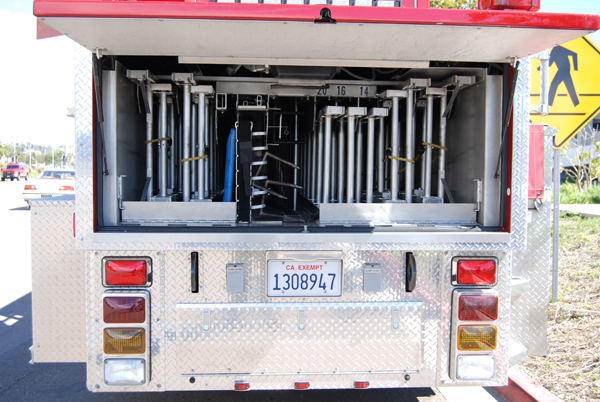 Aluminum ground ladders, including two 35-foot and two 28-foot extension ladders, are banked at the rear of the trailer. A backboard and pike poles are also nested here.
