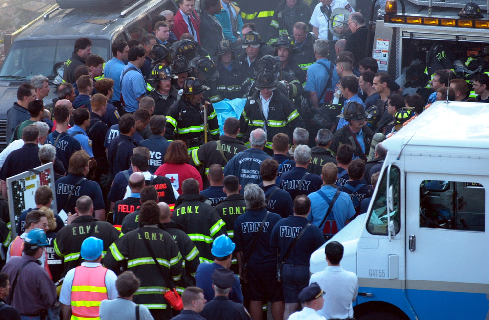 Firefighters from Rescue Company 4 carry Firefighter Brian Fahey, killed in the line of duty from the fire building to an ambulance as remaining firefighters remove their helmets in silent tribute. Emile Wamsteker/The New York Times/Redux