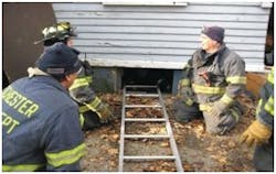 Photo 1. After the window is removed, take out the frame to enlarge the opening and place a straight or roof ladder into the opening. Photo 1. After the window is removed, take out the frame to enlarge the opening and place a straight or roof ladder into the opening.