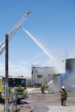 Operations Commander Battalion Chief Jim Dye, in foreground, oversees South Section operations. The fire has been declared under control and the ladder waterway is in “rescue mode,” which still provides adequate reach. The firefighter at the tip observes the big picture. Operations Commander Battalion Chief Jim Dye, in foreground, oversees South Section operations. The fire has been declared under control and the ladder waterway is in “rescue mode,” which still provides adequate reach. The firefighter at the tip observes the big picture.