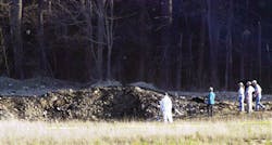 In this Tuesday, Sept. 11, 2001 file photo, emergency workers look at the crater created when United Airlines Flight 93 crashed near Shanksville, Pa.