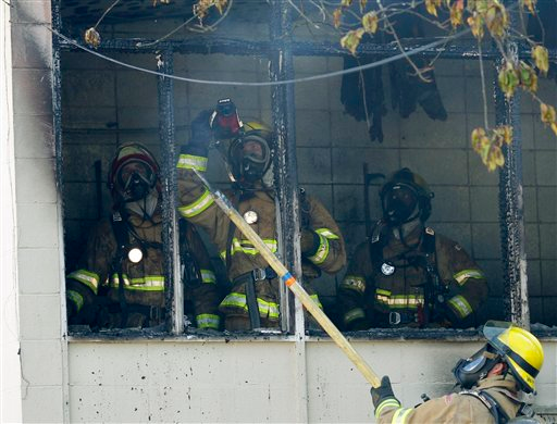 Tacoma firefighters look for hot spots following a fire in a kitchen area of a secondary wing of Lowell Elementary School.