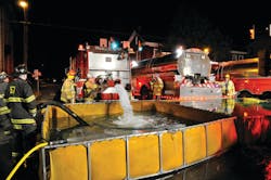 Robert Fulton Fire Company Tanker 5-13 dumps water into portable tanks that were set up in the Square of Strasburg Borough as part of the tanker-shuttle operation.