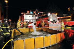 Robert Fulton Fire Company Tanker 5-13 dumps water into portable tanks that were set up in the Square of Strasburg Borough as part of the tanker-shuttle operation.