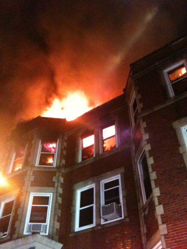 Firefighters rescued at least 15 people after an explosion sparked a massive fire that tore through a large apartment building early Monday.