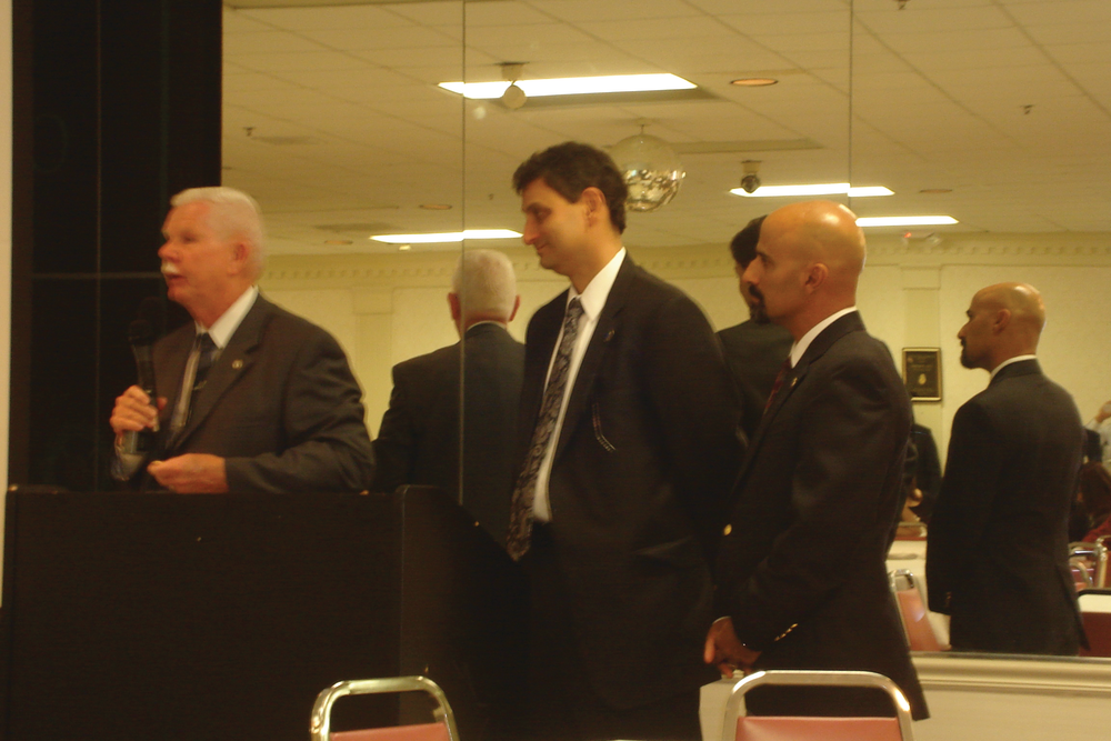 Former Deputy USFA Administrator Charlie Dickinson, left, presents challenge coins to Hal Bruno's sons, Harold, left, and Danny.