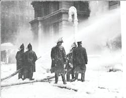 NEW YORK CITY, JAN. 9, 1912 &ndash; Firefighters operate hoselines from the dangerously icy street outside the burning Equitable Life Assurance Building at 120 Broadway in Manhattan. See page XX for a detailed account of the fire.