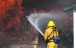 A Reno firefighter tries to save an outbuilding as a house burns in a 400-acre brush fire in south Reno, Nev., on Friday, Nov. 18, 2011. A Reno firefighter tries to save an outbuilding as a house burns in a 400-acre brush fire in south Reno, Nev., on Friday, Nov. 18, 2011.