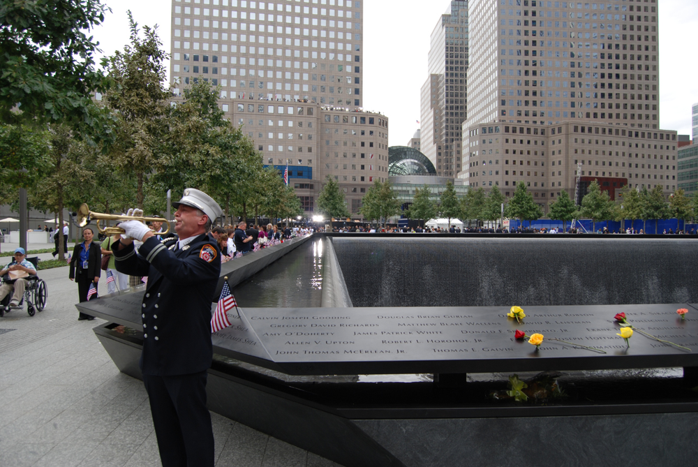 An FDNY firefighter is seen playing the trumpet next to the World Trade Center Memorial on Sept. 11, 2011.