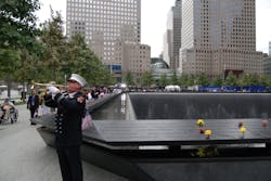 An FDNY firefighter is seen playing the trumpet next to the World Trade Center Memorial on Sept. 11, 2011.