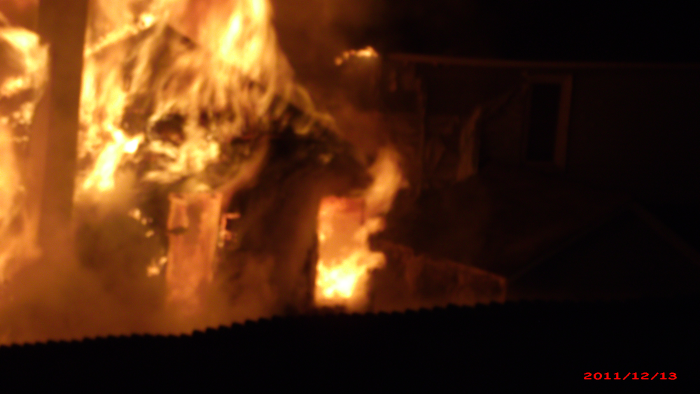 Fully engulfed two story structure fire that endangered two other occupied structures to each side.
