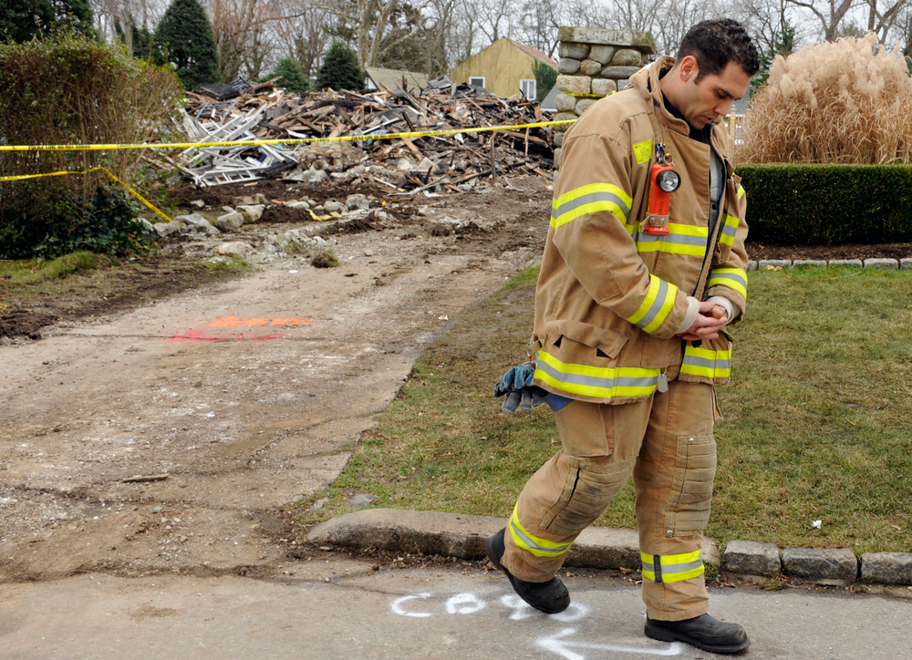 Stamford Firefighter Nick Tamburro pays respect outside the home of Madonna Badger.