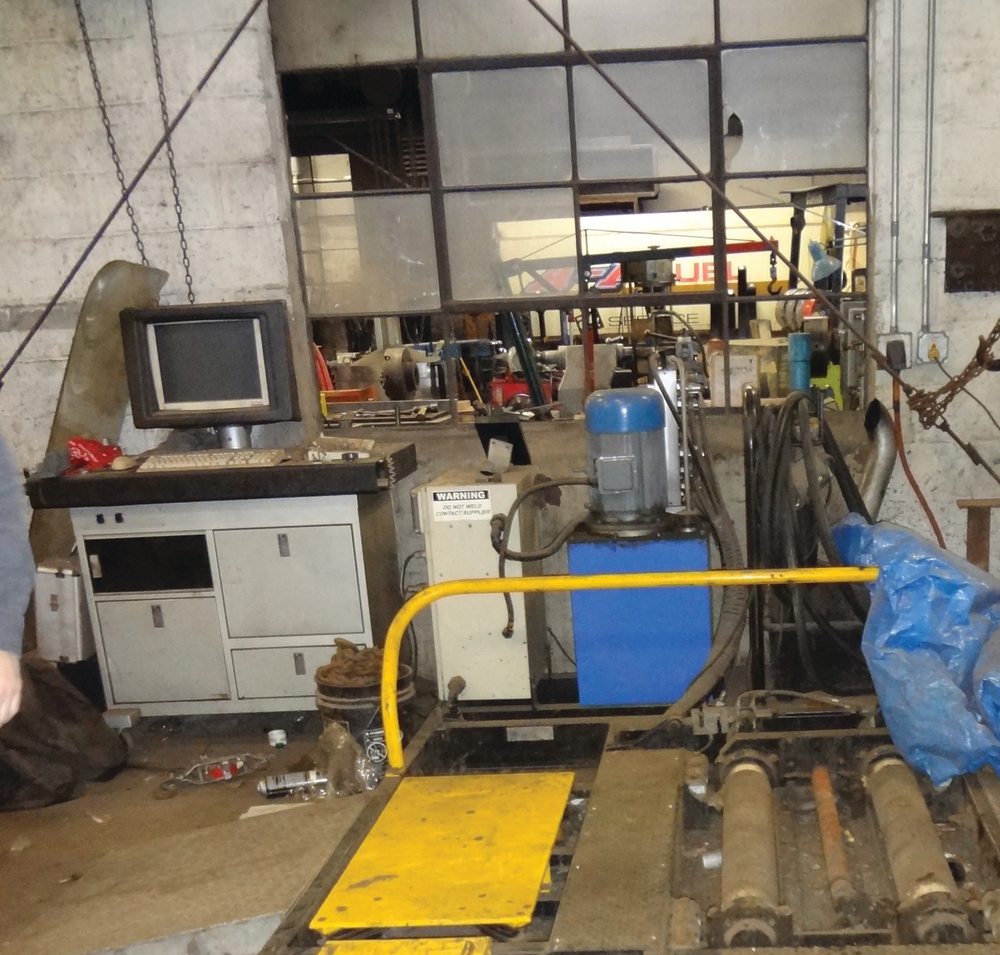 The machine is made up of several components. There is a desk with a computer screen and a printer. To the immediate right of the desk is a computer that captures information. To the right of the computer&rsquo;s brain is a blue cylindrical machine; that is the hydraulic pump that powers the rollers and the yellow panels that act as shakers.