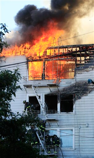 San Francisco firefighters climb down from a ladder at an apartment fire in the Western Addition area.
