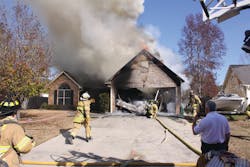 When the garage door collapsed, Assistant Chief Norman Cutshall requested the nozzle team to back up. Photos by Steve Skipton When the garage door collapsed, Assistant Chief Norman Cutshall requested the nozzle team to back up. Photos by Steve Skipton