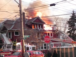 Units of the FDNY 22 Battalion on Staten Island, NY, operate at an early-morning second alarm. Ladder 79 operates its bucket as heavy fire vents through the attic roof. Illegal residents had been vacated from the attic days before the fire. During the fire, firefighters found at least 25 residents within the former single-family dwelling. Units of the FDNY 22 Battalion on Staten Island, NY, operate at an early-morning second alarm. Ladder 79 operates its bucket as heavy fire vents through the attic roof. Illegal residents had been vacated from the attic days before the fire. During the fire, firefighters found at least 25 residents within the former single-family dwelling.