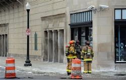 Firefighters talk near construction barrels that mark an open manhole and debris in front of Orchestra Hall on Feb. 12. Firefighters talk near construction barrels that mark an open manhole and debris in front of Orchestra Hall on Feb. 12.