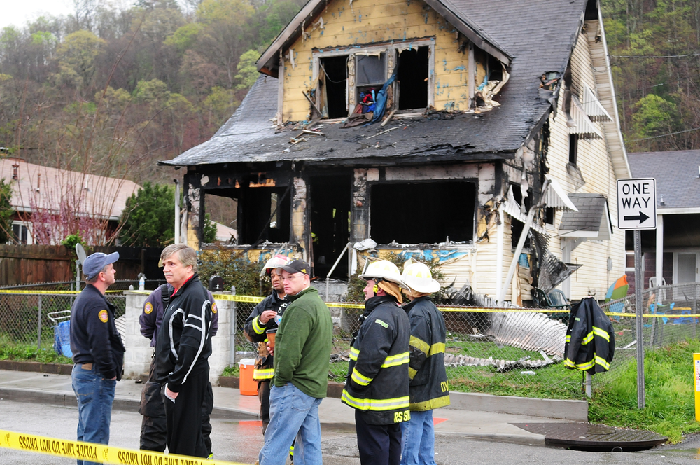 Mayor Danny Jones and Charleston, W.Va., firefighters look over the scene of a house fire on Saturday, March 24.