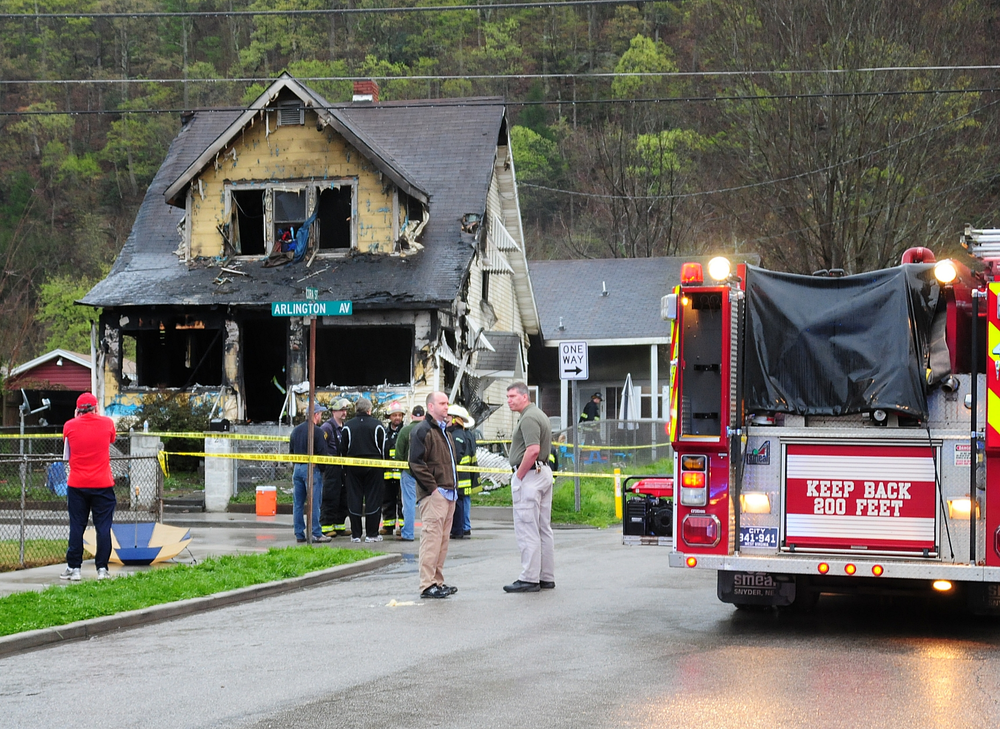Mayor Danny Jones and Charleston, W.Va., firefighters look over the scene of a house fire on Saturday, March 24.