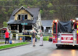 Mayor Danny Jones and Charleston, W.Va., firefighters look over the scene of a house fire on Saturday, March 24.
