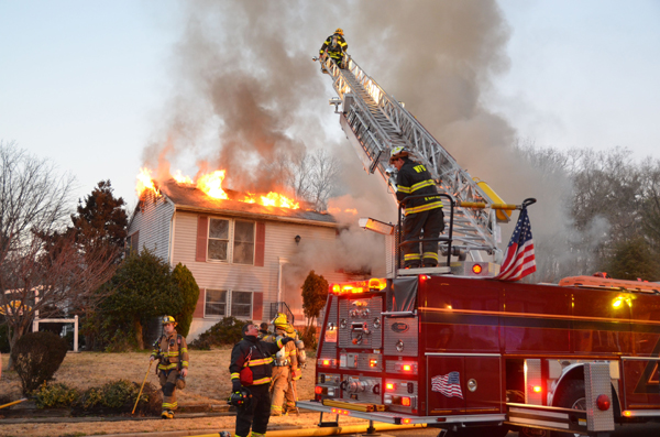 Crews position a ladder at a New Jersey house fire.