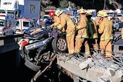 Upon arrival of the first units, a tractor-trailer truck had rear-ended a car. The truck dragged the car under its wheels and crashed through the bridge. Landing 100 feet below, the truck caught fire and the car was hanging off the highway directly above. Upon arrival of the first units, a tractor-trailer truck had rear-ended a car. The truck dragged the car under its wheels and crashed through the bridge. Landing 100 feet below, the truck caught fire and the car was hanging off the highway directly above.