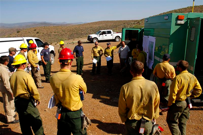 Firefighters receive an update on the Gladiator Fire during a meeting in Cleator, Ariz. on May 17.