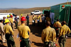 Firefighters receive an update on the Gladiator Fire during a meeting in Cleator, Ariz. on May 17.