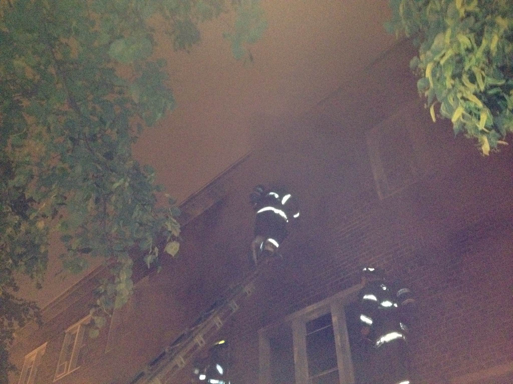 Baltimore firefighters ventilate the front third-floor during a fire at a house on West Lexington Street where three children were rescued on May 6.