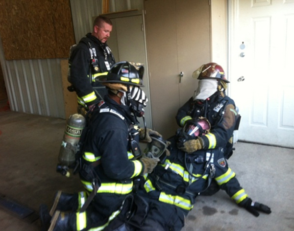 A captain and crew practicing face piece replacement during a company training session.
