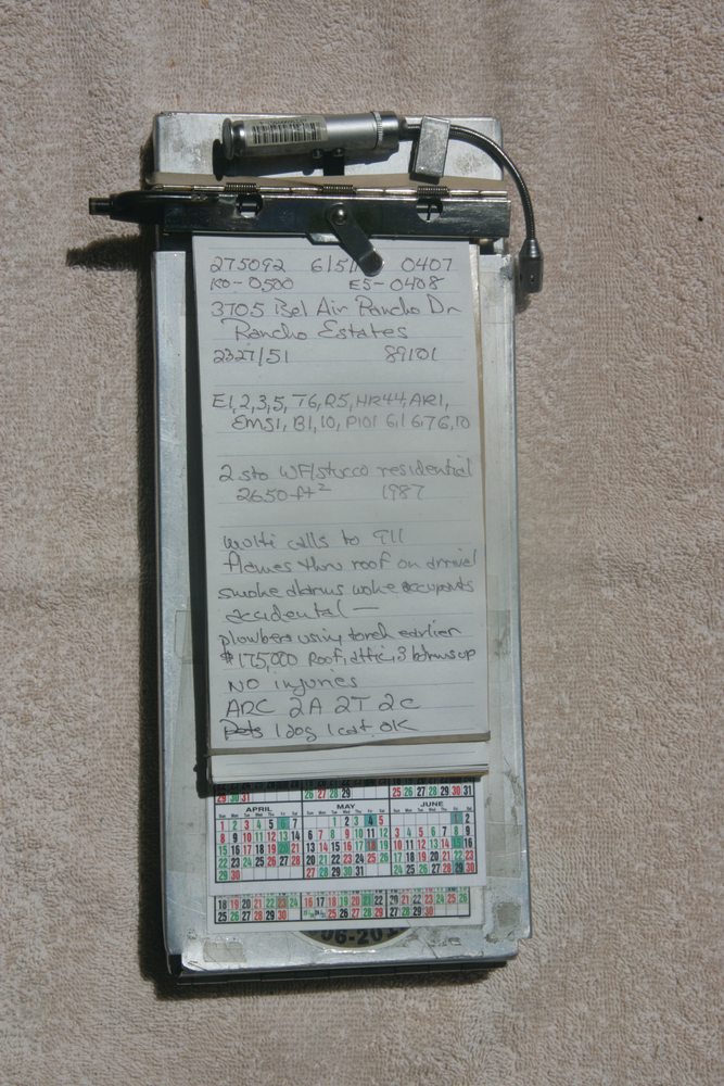 A reporter&rsquo;s notebook on a 'citation holder.' Notice the pen, mini light for darkness and rubber band on the bottom of the notebook.
