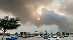A plume of smoke blots out the sun over the Santa Rosa Mall in Mary Esther, Fla. on May 29.