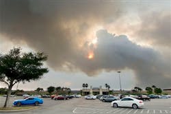 A plume of smoke blots out the sun over the Santa Rosa Mall in Mary Esther, Fla. on May 29.