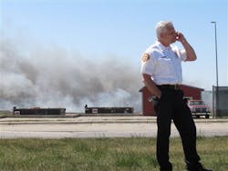 Iowa City Fire Chief Andy Rocca speaks on his cellphone at the site of a fire at a city-owned landfill on May 29. Iowa City Fire Chief Andy Rocca speaks on his cellphone at the site of a fire at a city-owned landfill on May 29.