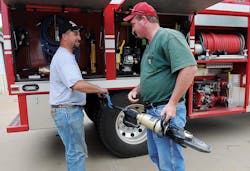 Kremlin Firefighter Chris Henry, left and Fire Chief Derrick Harris check out hydraulic extrication tools used to free two teens following a grain auger accident last August.