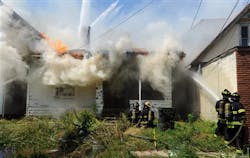 Firefighters fight a fire at vacant house along West Second Street near Plum Street in Owensboro, Ky. on May 23.