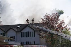 Firefighters battled a two-alarm fire at a condominium complex on May 16 where two firefighters were injured and another came out unscathed after falling through the roof. Firefighters battled a two-alarm fire at a condominium complex on May 16 where two firefighters were injured and another came out unscathed after falling through the roof.