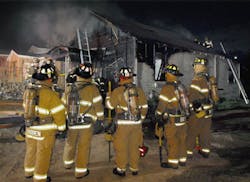 A rapid intervention team stands ready at a house fire in Fort Worth, TX.