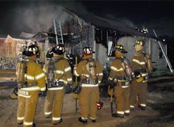 A rapid intervention team stands ready at a house fire in Fort Worth, TX. A rapid intervention team stands ready at a house fire in Fort Worth, TX.