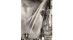 Firefighters attack a seven-alarm fire in downtown Baltimore, MD, on May 9, 1938.