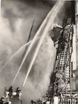Firefighters attack a seven-alarm fire in downtown Baltimore, MD, on May 9, 1938.