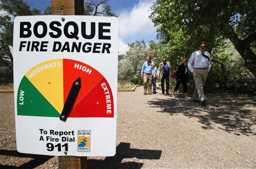 State forestry officials walk down a path at the Rio Grande Nature Center in Albuquerque, N.M., following a news conference on a new wildfire email notification system.