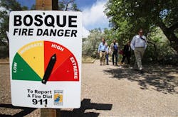 State forestry officials walk down a path at the Rio Grande Nature Center in Albuquerque, N.M., following a news conference on a new wildfire email notification system.
