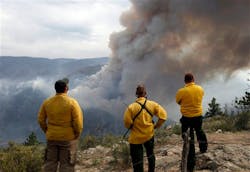 Firefighters watch as flames leap hundreds of feet in the air as the High Park wildfire fire explodes on the south side of Poudre Canyon west of Fort Collins, Colo. on June 14.