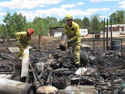 Two firefighters mop up after a small wildfire on the outskirts of Mountain Home, Idaho on June 19.