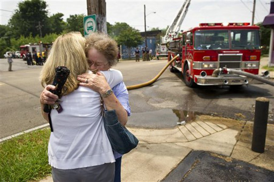Carol Britton, right, and her daughter Deena Scroggins embrace while across the street as firefighters work to put out a fire that consumed their family-owned business, Mid Continent Laboratories on May 31.