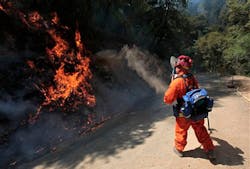An inmate firefighter from the Eel River Conservation camp throws dirt on flames from the Robbers Fire near Iowa Hill, Calif. on July 12. An inmate firefighter from the Eel River Conservation camp throws dirt on flames from the Robbers Fire near Iowa Hill, Calif. on July 12.