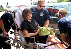 Paramedics with the Mount Prospect Fire Department load Laura Barros, assistant executive director of the Illinois Fire Safety Alliance, into an ambulance after her foot was burned. Paramedics with the Mount Prospect Fire Department load Laura Barros, assistant executive director of the Illinois Fire Safety Alliance, into an ambulance after her foot was burned.